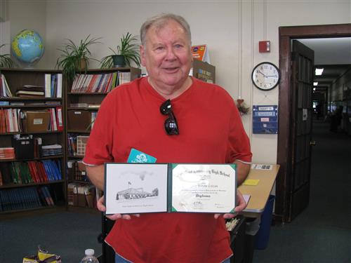 Adult learner holding high school diploma earned through Metro North ABE. 